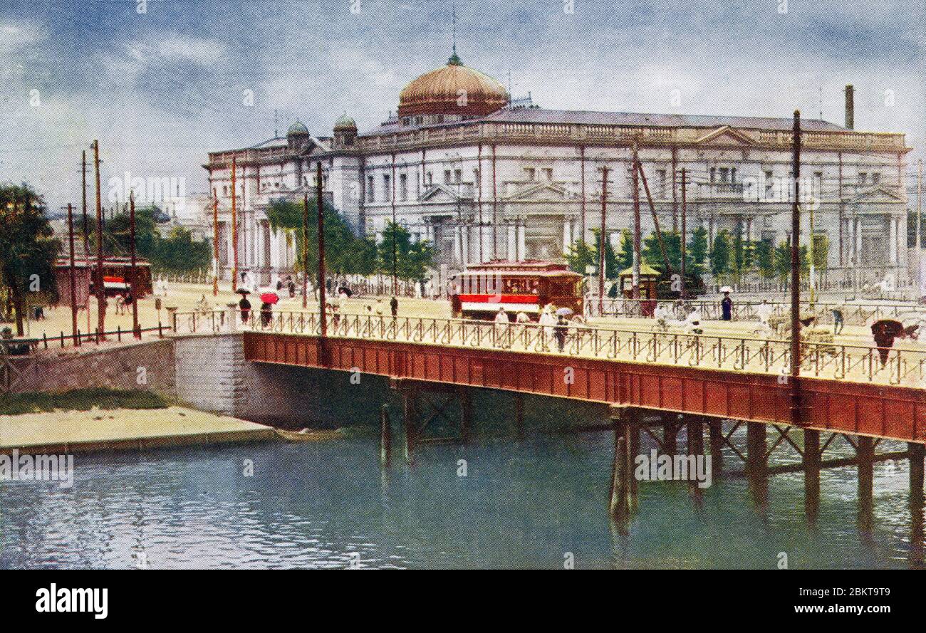 [ Giappone degli anni '10 - Banca Centrale del Giappone a Osaka ] - Ponte di Oebashi (大江橋) che attraversa il fiume Dojimagawa e la filiale di Osaka della Banca Centrale del Giappone a Nakanoshima, Osaka. Progettato da Kono Tatsuno (辰野金吾, 1854–1919), Manji Kasai (葛西萬司, 1863-1942) e Uheiji Nagano (長野宇平治, 1867-1937), la banca è stata completata nel 1903 (Meiji 36). cartolina vintage del xx secolo. Foto Stock