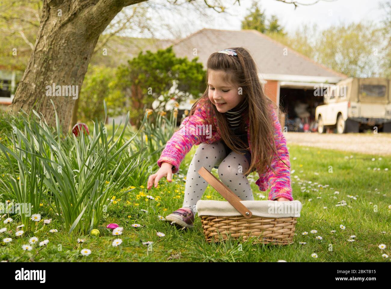 Giovane ragazza a caccia di uova di pasqua Foto Stock