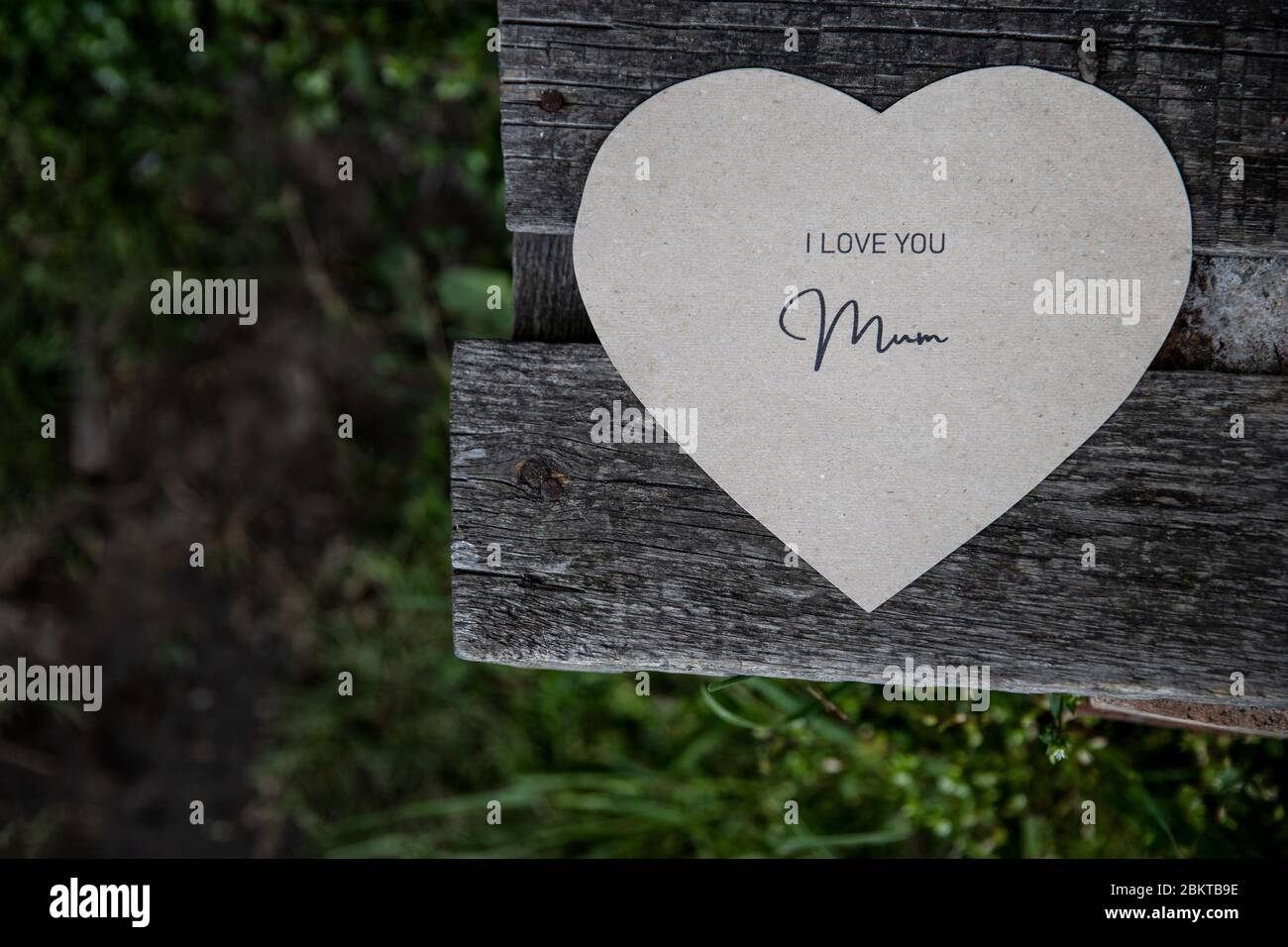 Ti amo mamma scritta su una carta su una vecchia panchina rustica Foto Stock