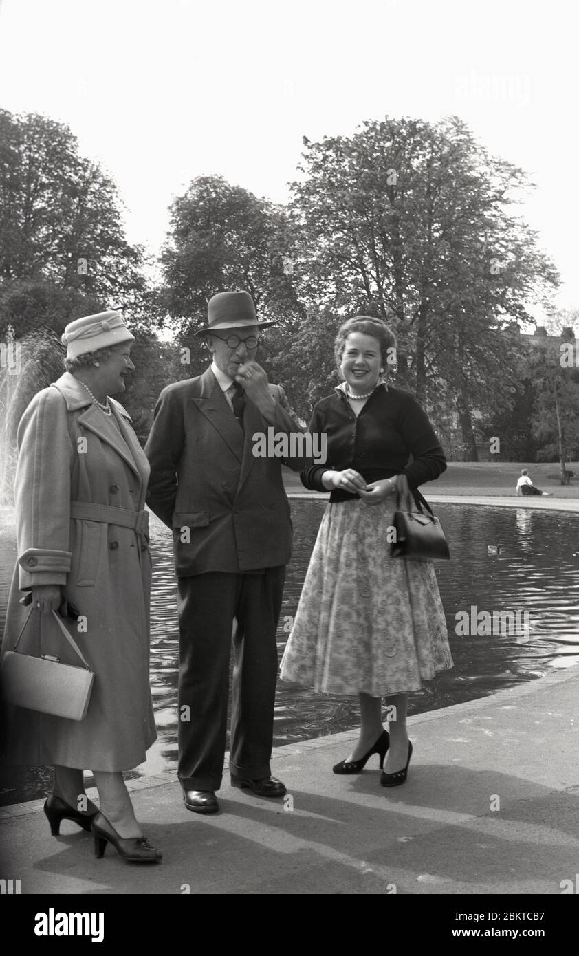 Anni '50, storico, anziani, ben vestiti coppia, entrambi con cappello, in  piedi per una foto da un lago di barca, con la loro figlia, Inghilterra,  Regno Unito Foto stock - Alamy