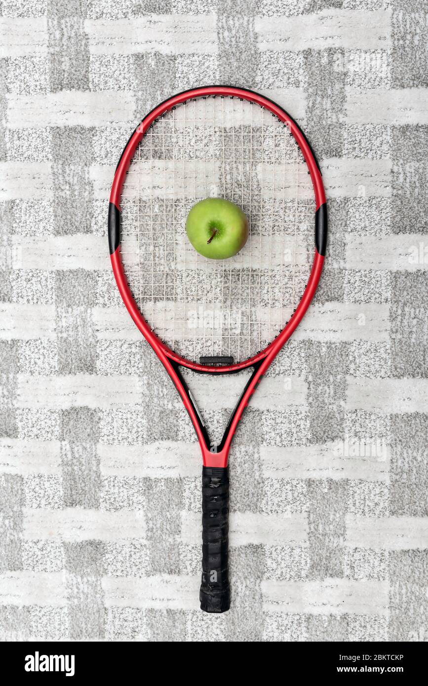 Racchetta da tennis con mela verde Foto Stock
