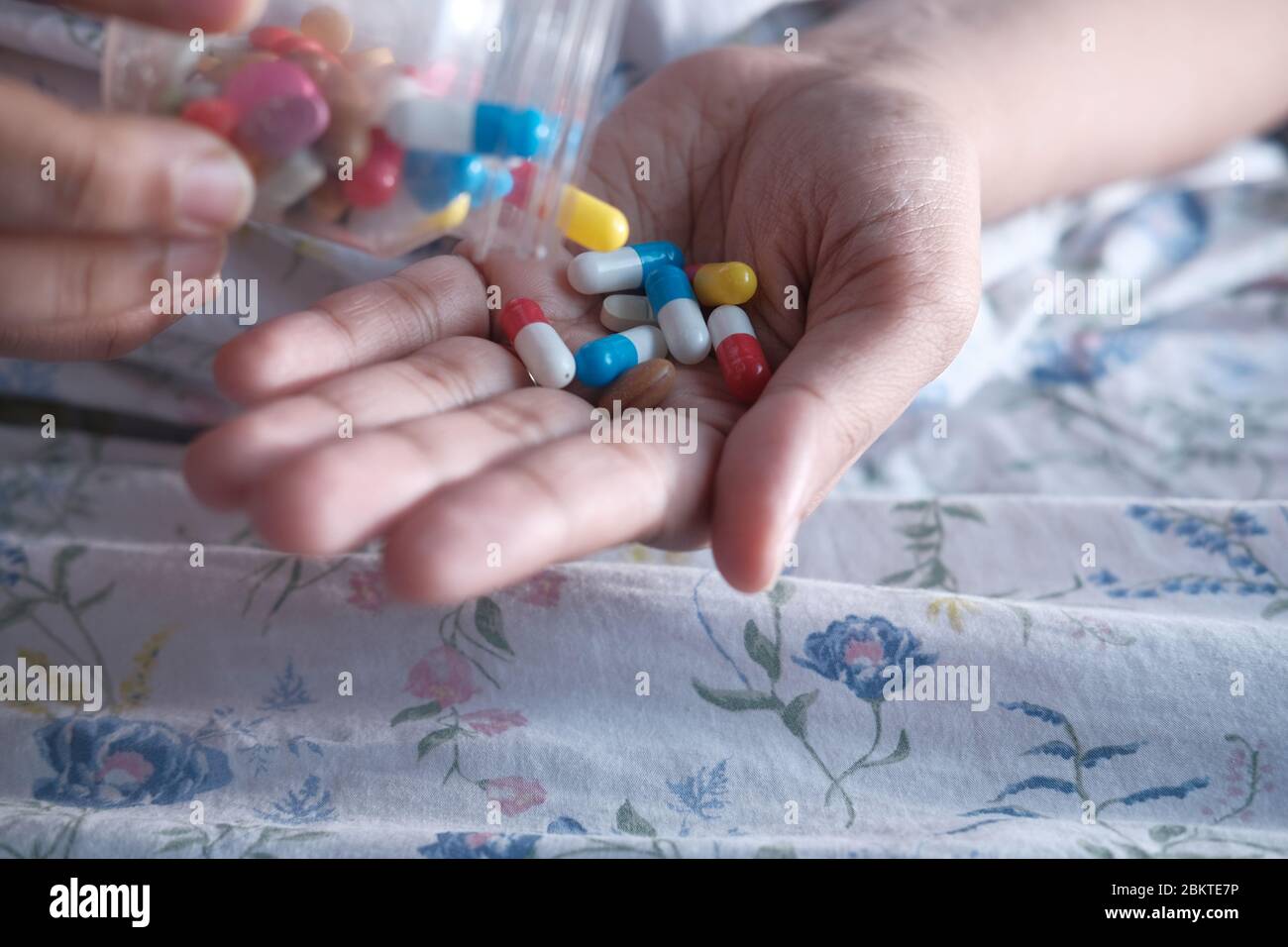 donna che versa pillole da bottiglia a portata di mano Foto Stock
