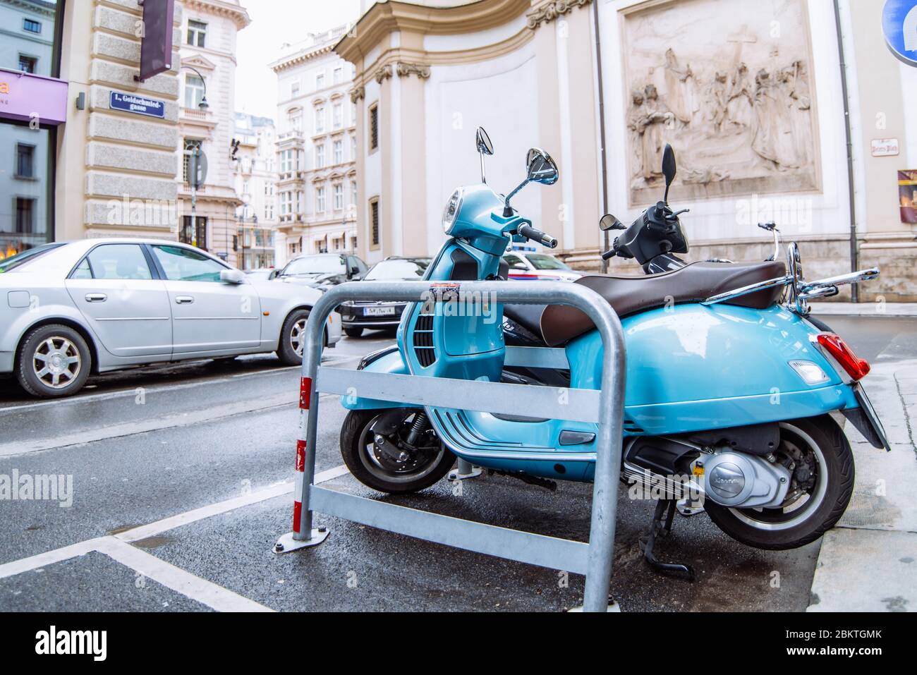 scooter blu ciclomotore parcheggiato sul lato strada della città Foto Stock
