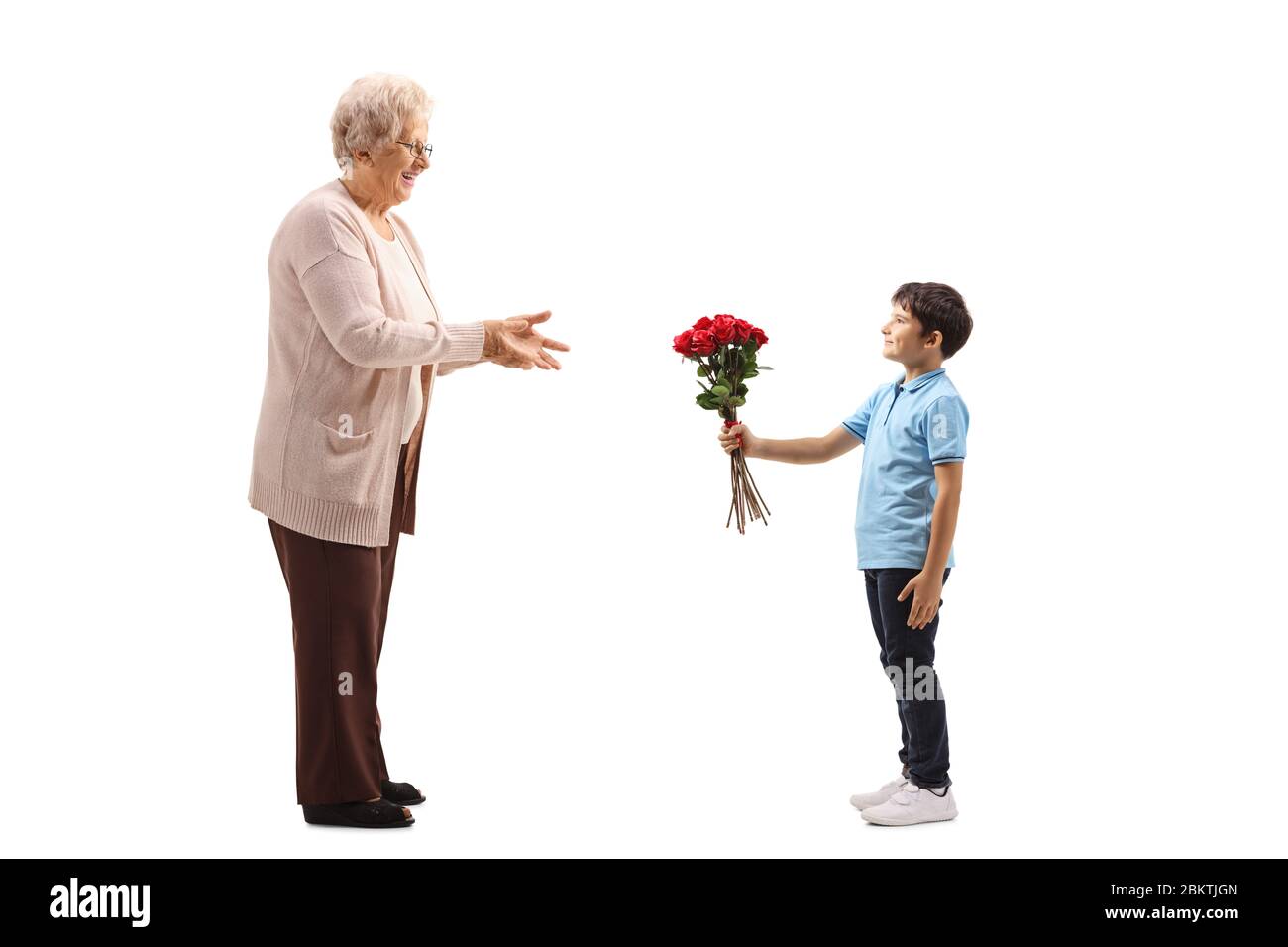 Scatto a tutta lunghezza di un ragazzo che dà un mazzo di rose rosse ad una donna anziana isolata su sfondo bianco Foto Stock