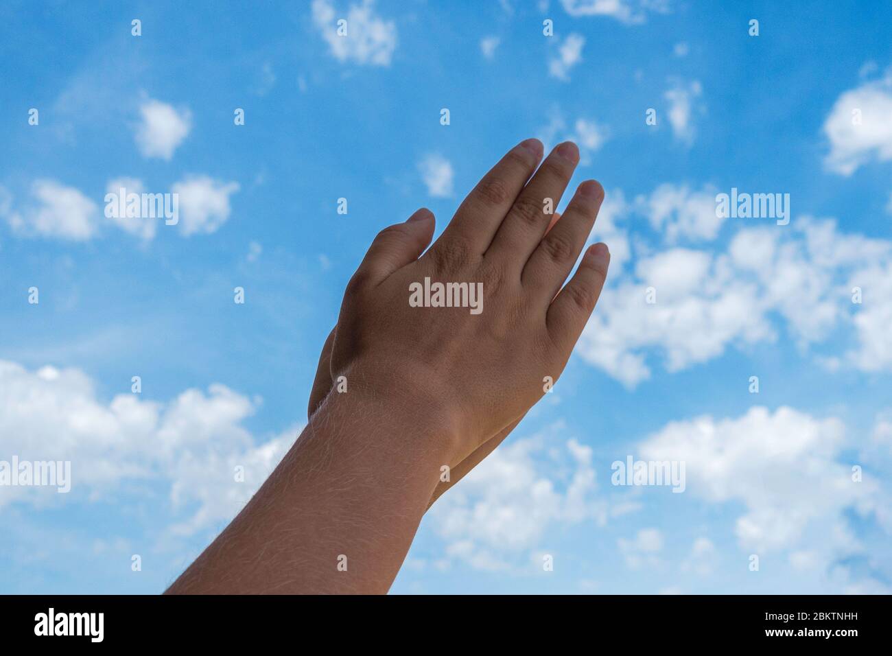 Applausi. Mani di capretto applauding sopra sfondo blu del cielo. Vista ad angolo basso Foto Stock