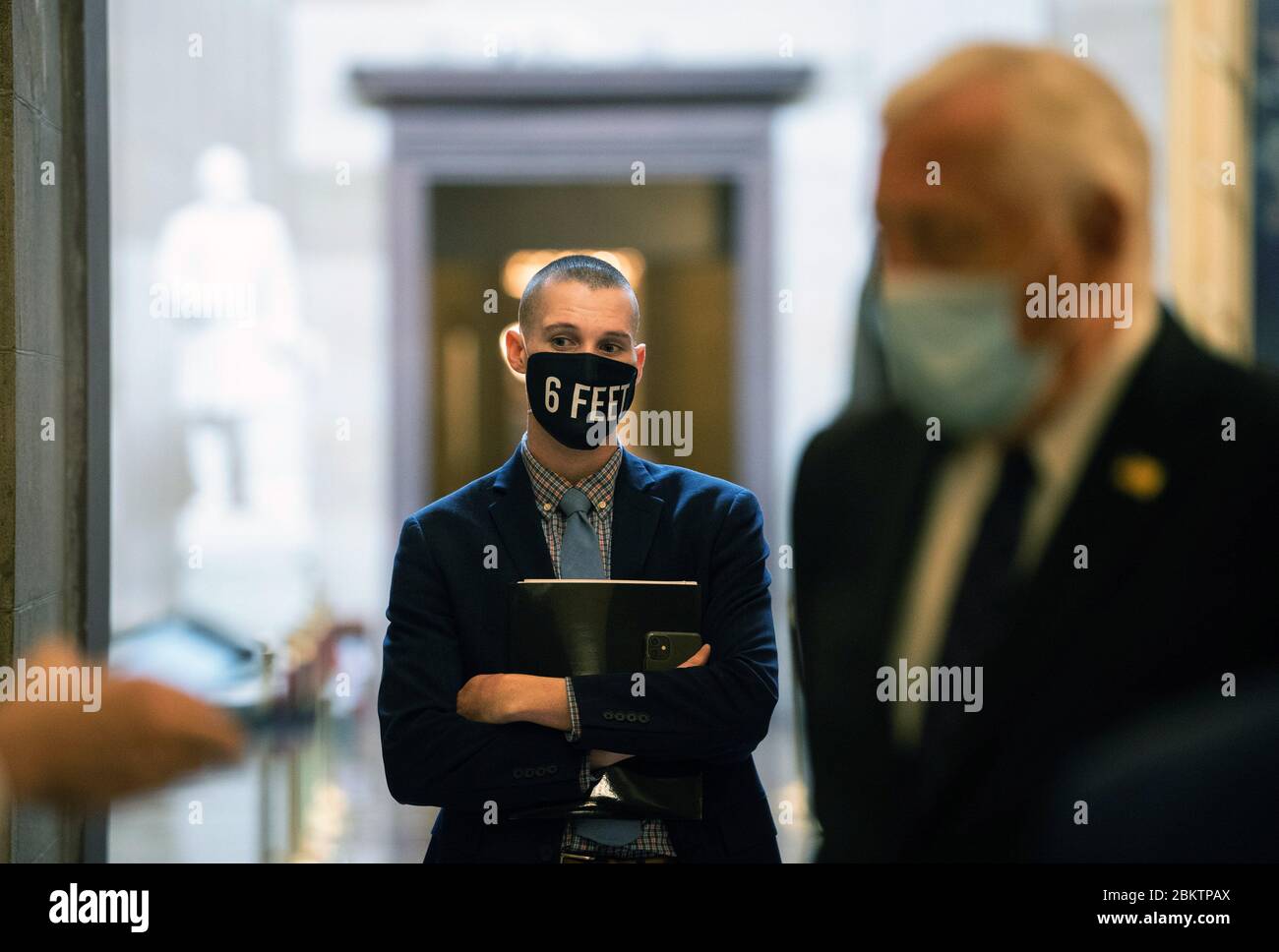 Washington, Stati Uniti. 05 maggio 2020. Un membro dello staff per la maggioranza della Camera leader Steny Hoyer, D-MD, indossa una maschera che ricorda di sociale-distanziare mentre guarda come Hoyer parla a un reporter, al Campidoglio degli Stati Uniti a Washington, DC Martedì, 5 maggio 2020. Foto di Kevin Dietsch/UPI Credit: UPI/Alamy Live News Foto Stock