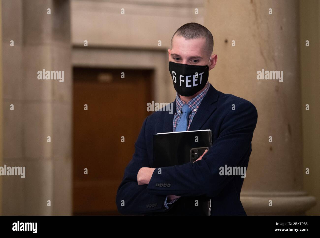 Washington, Stati Uniti. 05 maggio 2020. Un membro dello staff per la maggioranza della Camera leader Steny Hoyer, D-MD, indossa una maschera che ricorda di sociale-distanziare mentre guarda come Hoyer parla a un reporter, al Campidoglio degli Stati Uniti a Washington, DC Martedì, 5 maggio 2020. Foto di Kevin Dietsch/UPI Credit: UPI/Alamy Live News Foto Stock