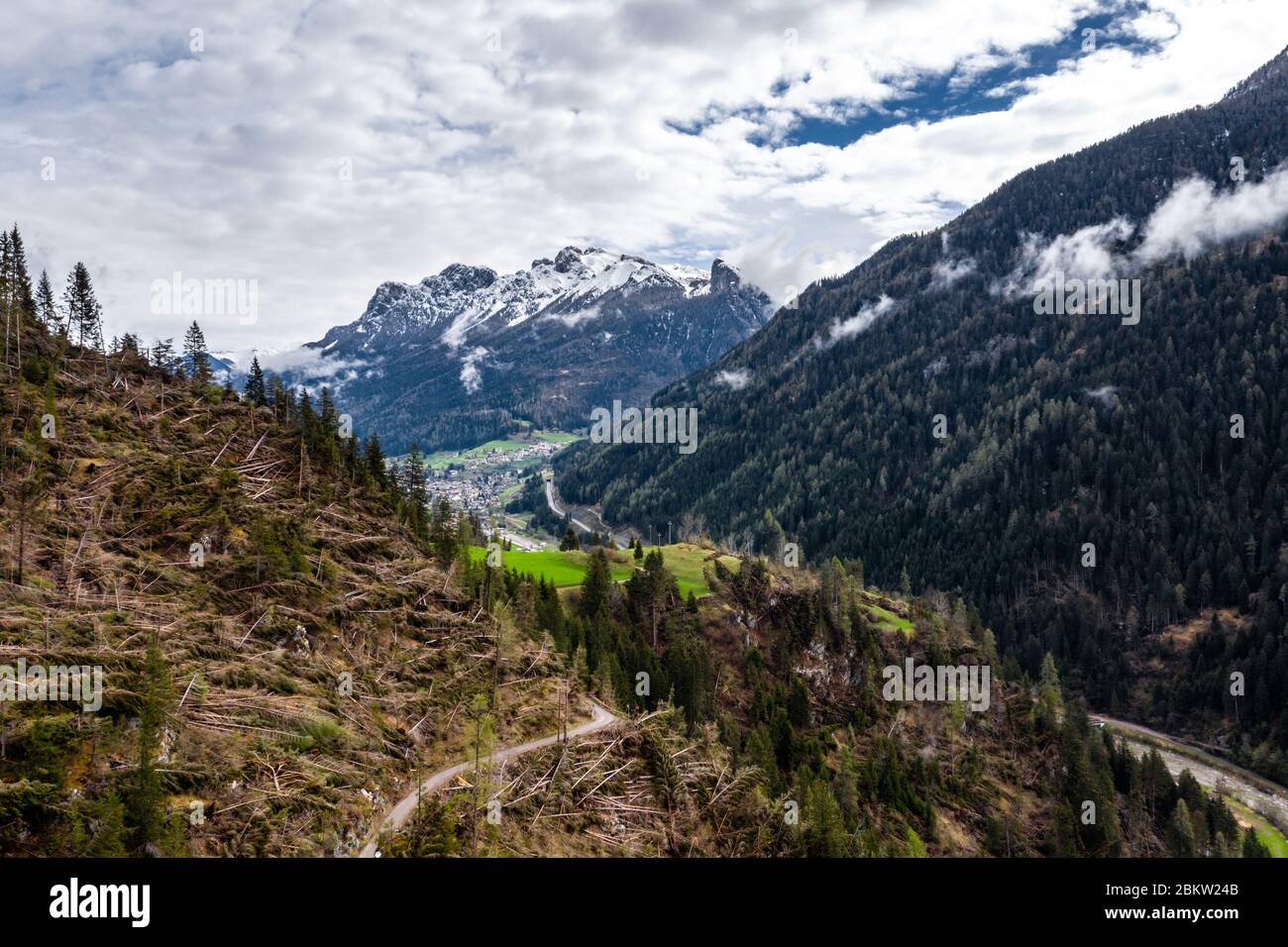 Veduta aerea della valle con verdi pendici delle montagne d'Italia tempo nuvoloso, Trentino, gli alberi caduti dal vento, enormi nuvole su un Foto Stock