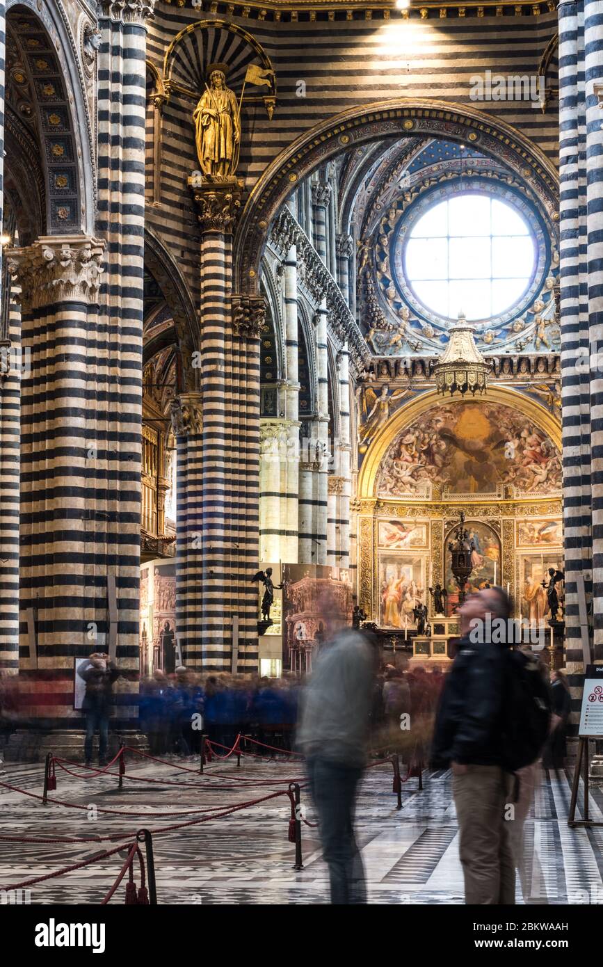 SIENA, ITALIA - 13, MARZO, 2018: Foto a lunga esposizione di turisti commoventi all'interno della Cattedrale cattolica di Siena, uno dei migliori luoghi di Siena Foto Stock