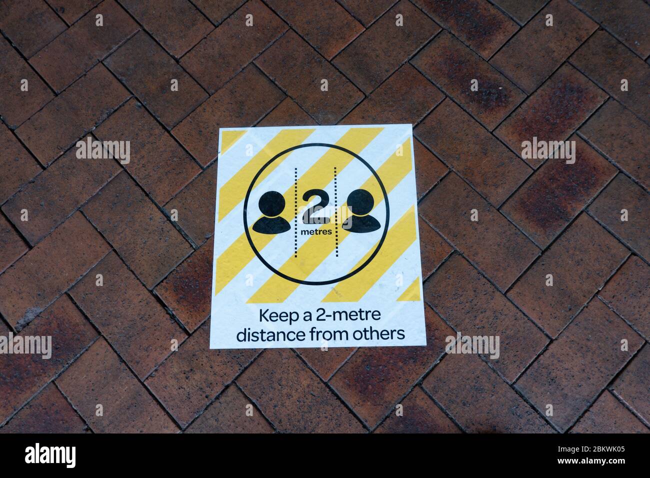 Tauranga Nuova Zelanda - Maggio 5 2020; Covid-19 2 metri sociale distanziando i segnali di pavimentazione fornendo istruzioni per il mantenimento di fisico appropriato Foto Stock
