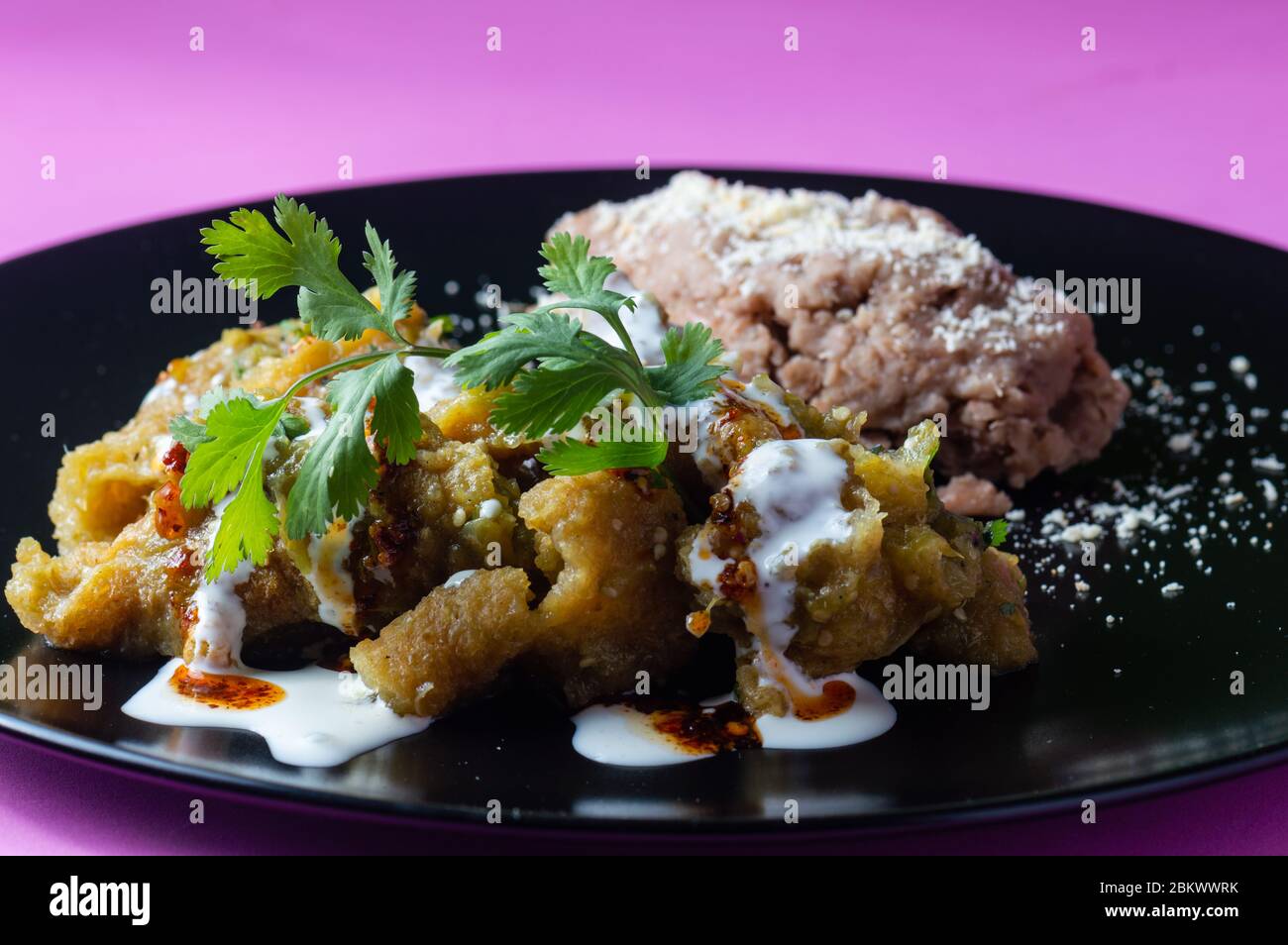 Si insaccano i suini in salsa verde con fagioli fritti Foto Stock