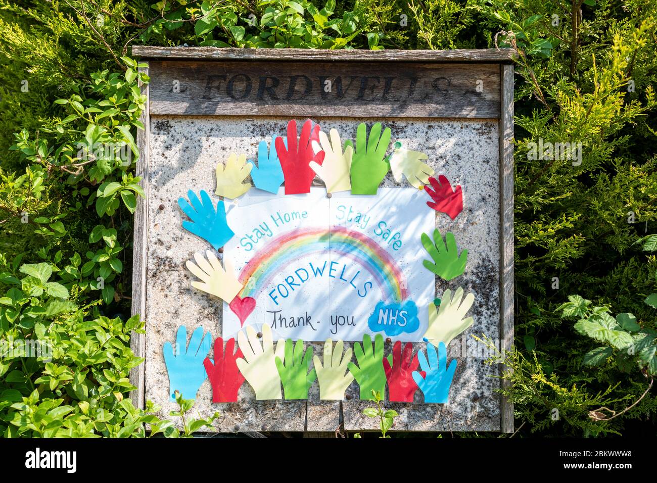 Poster di ringraziamento - mani d'aiuto e arcobaleno - da parte della gente del villaggio locale in lode del Servizio sanitario Nazionale - NHS - durante Coronavirus COVID-19 vi Foto Stock