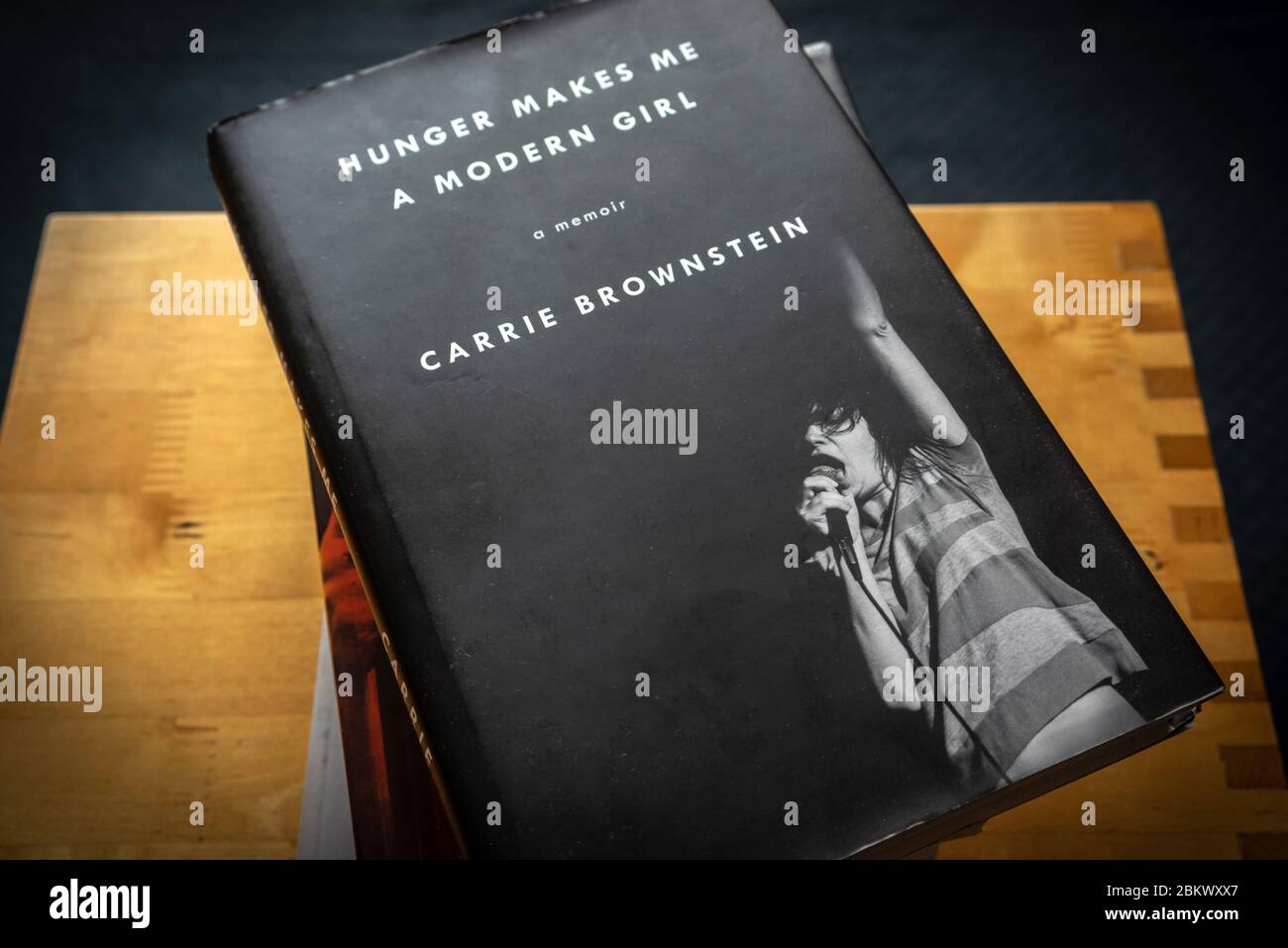 Una copia di 'la fame mi rende una ragazza moderna' - un memoriale di Carrie Brownstein in cima ad una pila di libri Foto Stock
