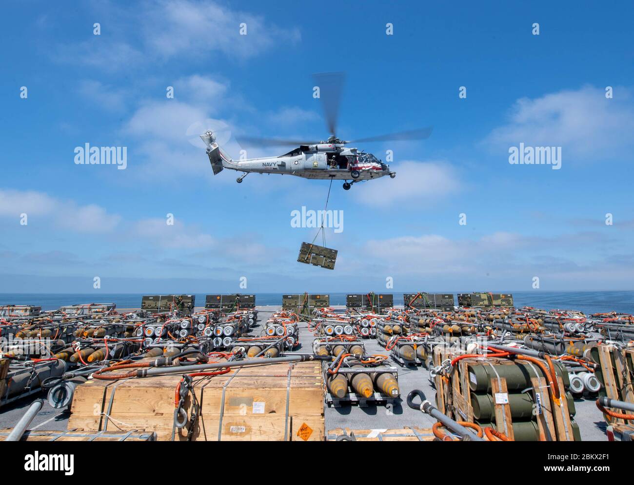 200504-N-NG710-1709 OCEANO PACIFICO (4 maggio 2020) un MH-60S Seahawk attaccato a elicottero Sea Combat Squadron (HSC) 21 solleva la lancia dal ponte di volo della nave d'assalto anfibio USS Boxer (LHD 4) durante un trasferimento di munizioni. Boxer sta conducendo operazioni di routine nel Pacifico orientale. (STATI UNITI Foto Navy di Mass Communication Specialist 2a classe Justin Daniel Rankin) Foto Stock