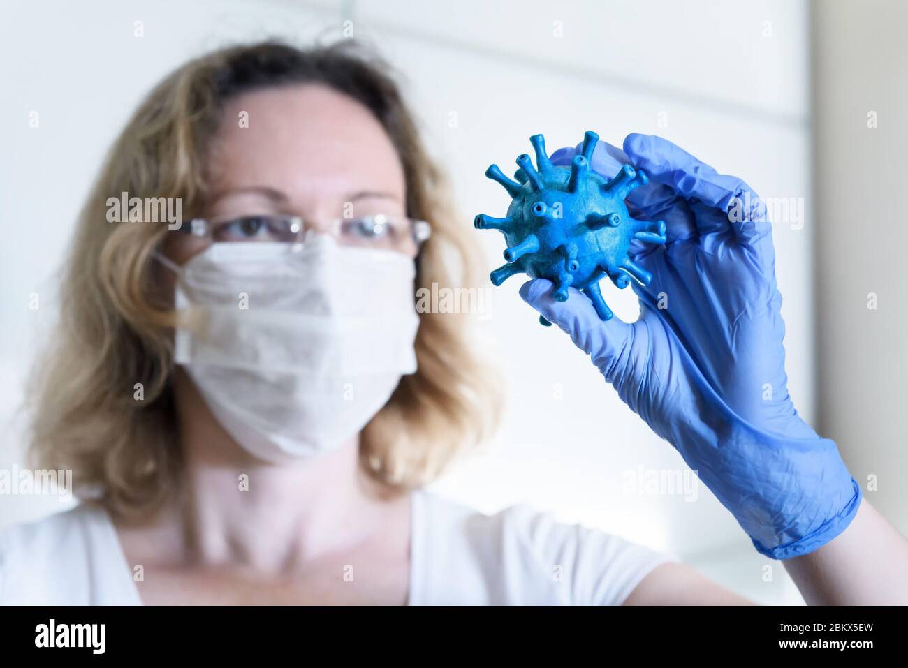 Coronavirus e scienza concetto, donna ricercatore tiene in mano il virus corona, ricerca scientifica e medica durante COVID-19 pandemic. Sviluppo di Foto Stock