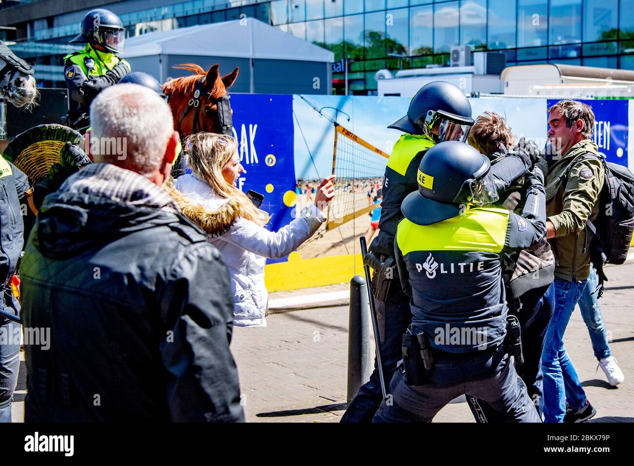 Polizia antisommossa che arrestava un dimostratore durante la protesta.decine di attivisti anti-blocco sono stati arrestati mentre dimostravano contro le misure del virus corona all'Aia. Foto Stock