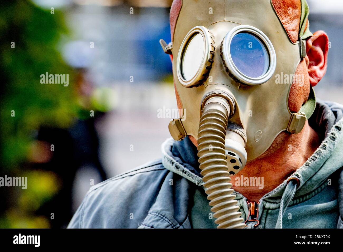 Un dimostratore che indossa una maschera a gas durante la protesta.decine di attivisti anti-blocco sono stati arrestati mentre dimostravano contro le misure contro il virus corona all'Aia. Foto Stock
