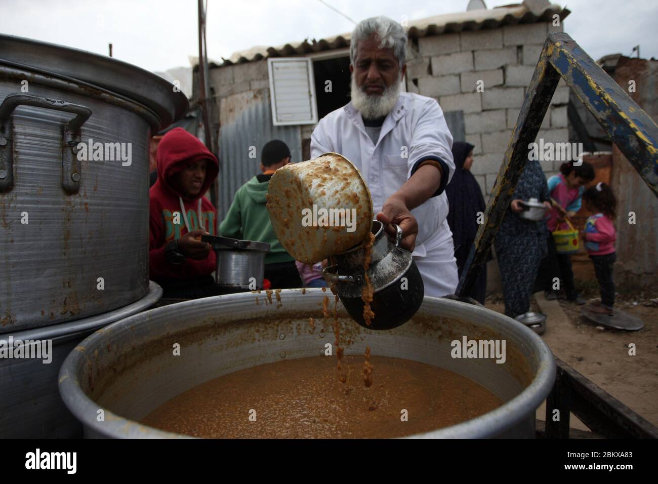 Rafah, Gaza. 05 maggio 2020. I palestinesi ricevono una porzione di zuppa, passata alle famiglie povere, durante il mese sacro islamico del Ramadan, a Rafah nella striscia meridionale di Gaza, martedì 5 maggio 2020, durante la pandemia del coronavirus COVID-19. Foto di Ismael Mohamad/UPI Credit: UPI/Alamy Live News Foto Stock