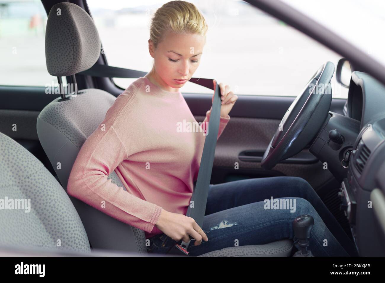 Bella donna allacciare la cintura di sicurezza in auto piccola personale  Foto stock - Alamy