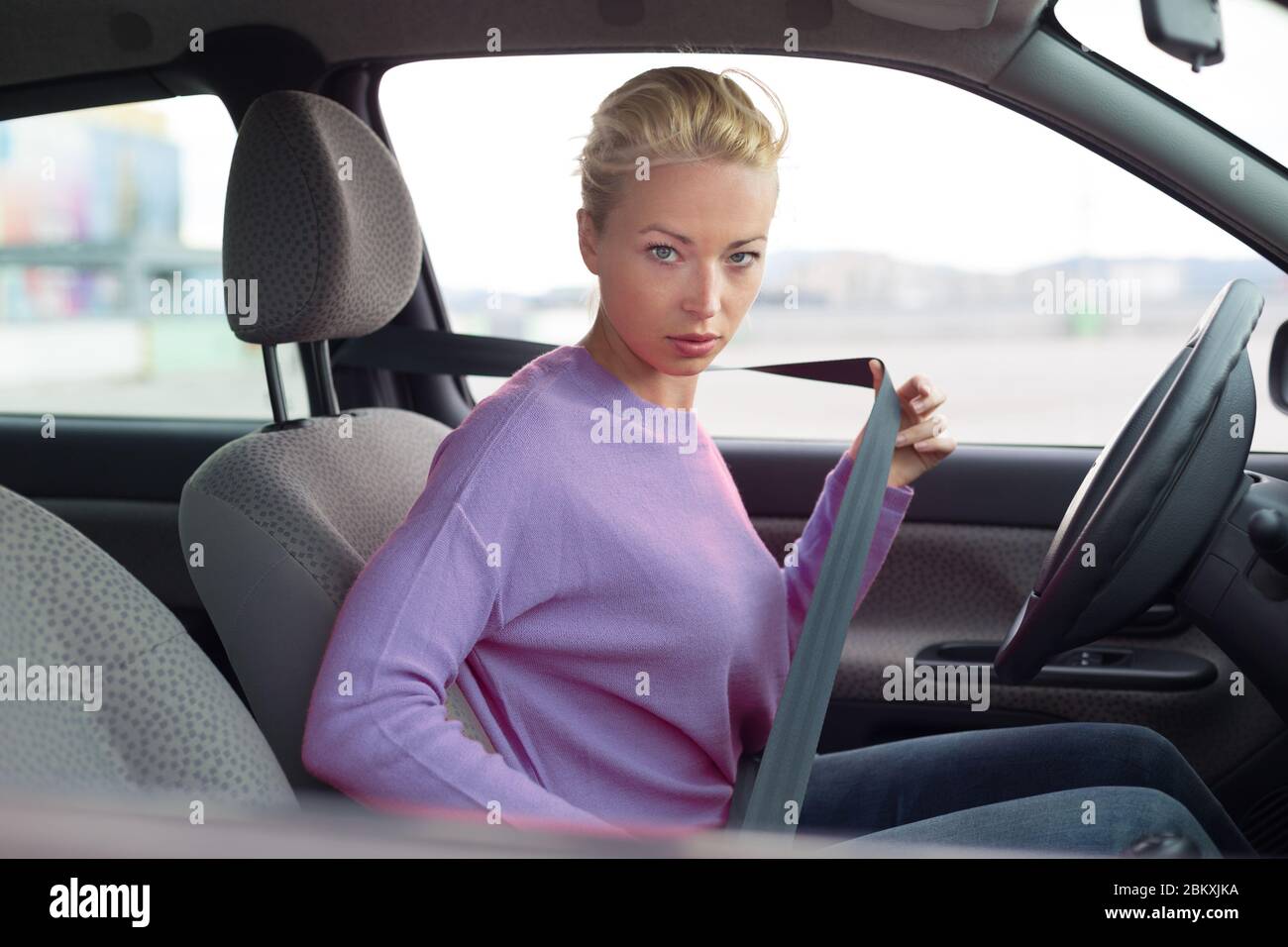 Bella donna allacciare la cintura di sicurezza in auto piccola personale  Foto stock - Alamy