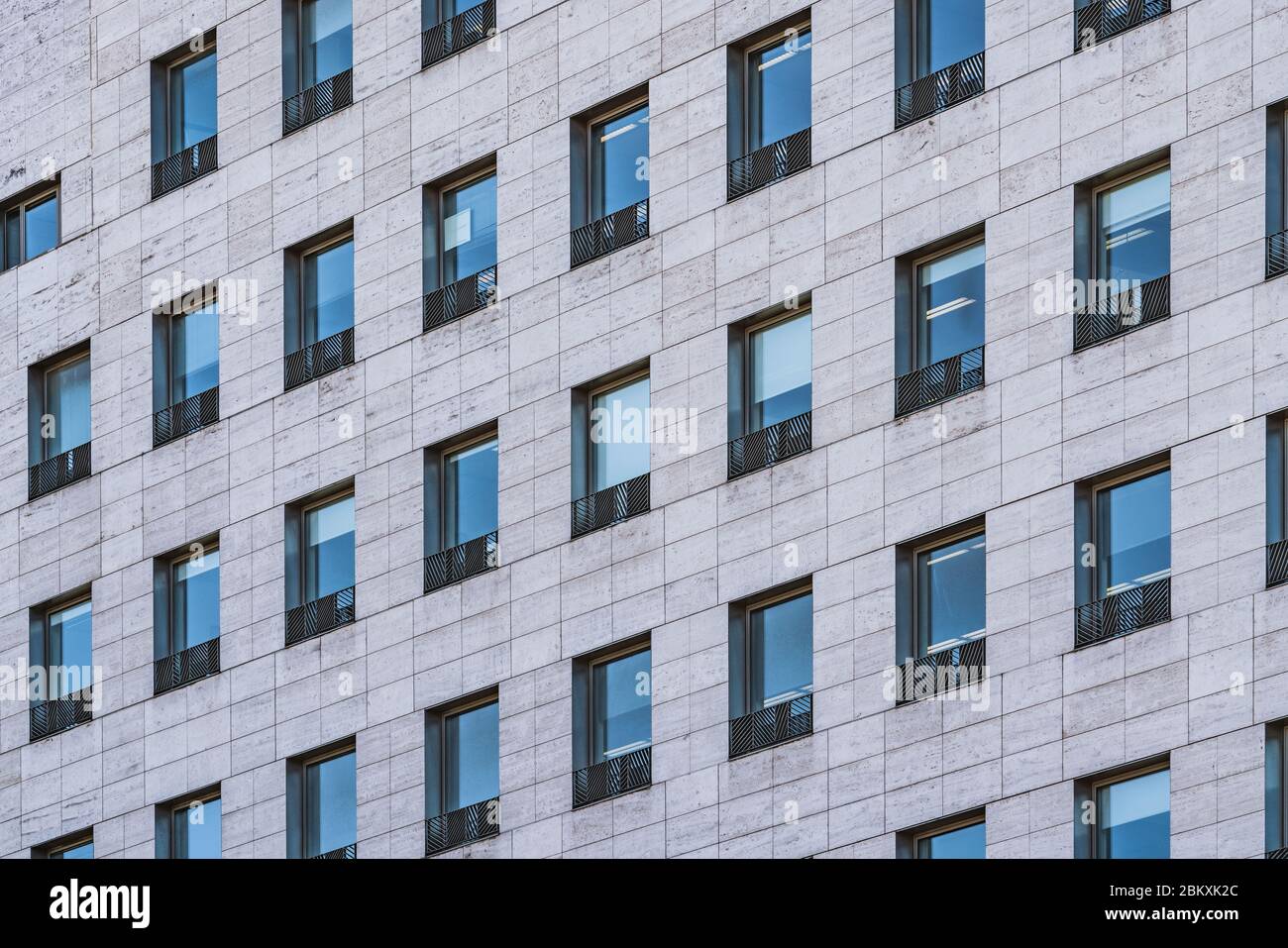 File di finestre di un edificio aziendale costruito in marmo travertino romano Foto Stock