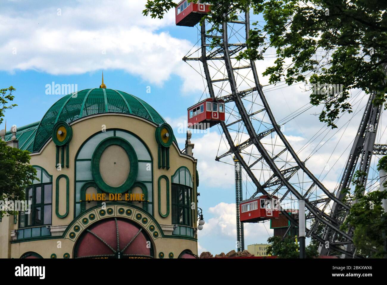 Ruota panoramica e edificio di benvenuto con il saluto austriaco 'Habe die Ehre' a Prater, il parco divertimenti pubblico di Vienna, capitale dell'Austria. Foto Stock