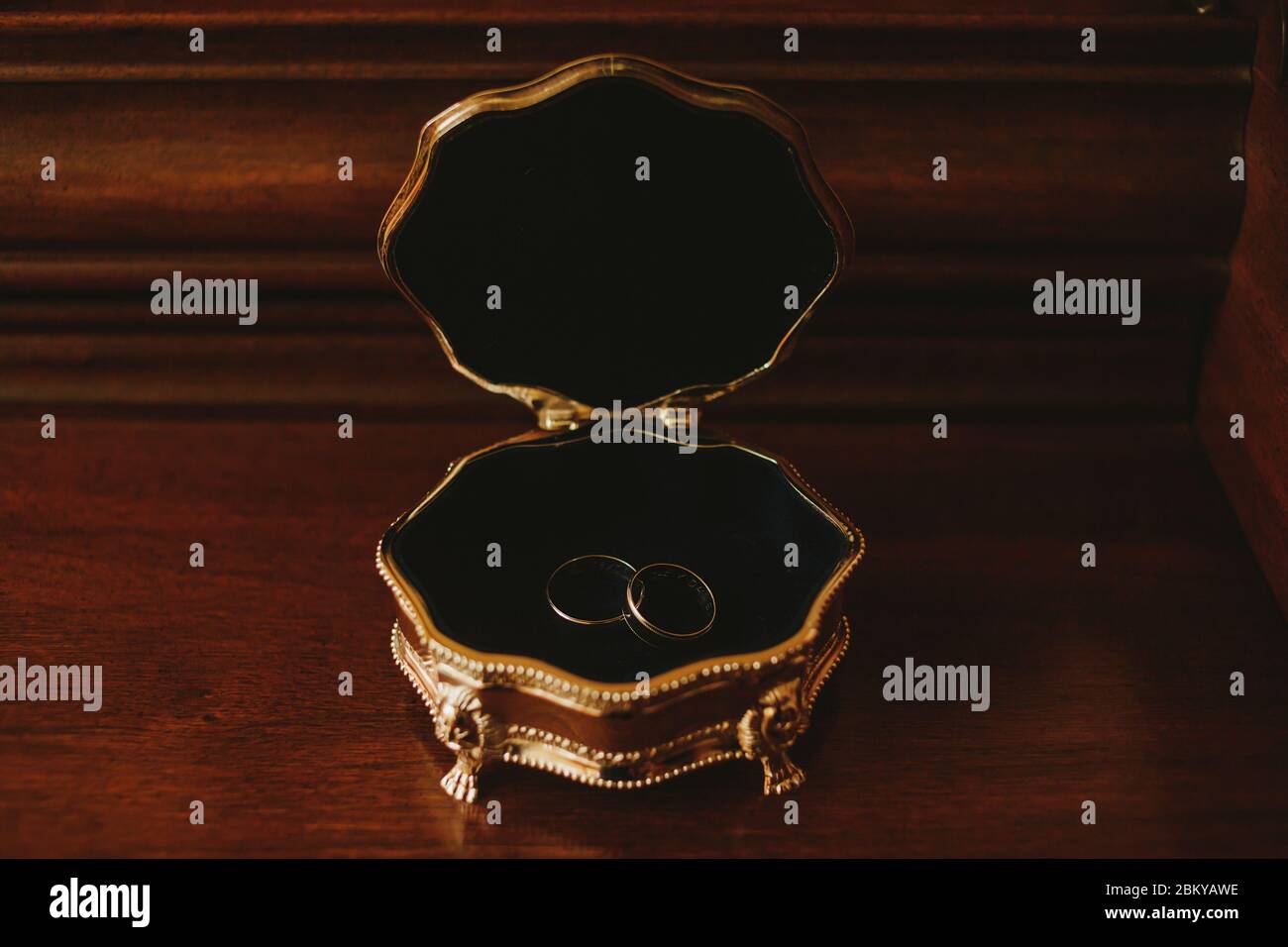 anelli di nozze sul supporto per anelli su uno sfondo di legno Foto Stock