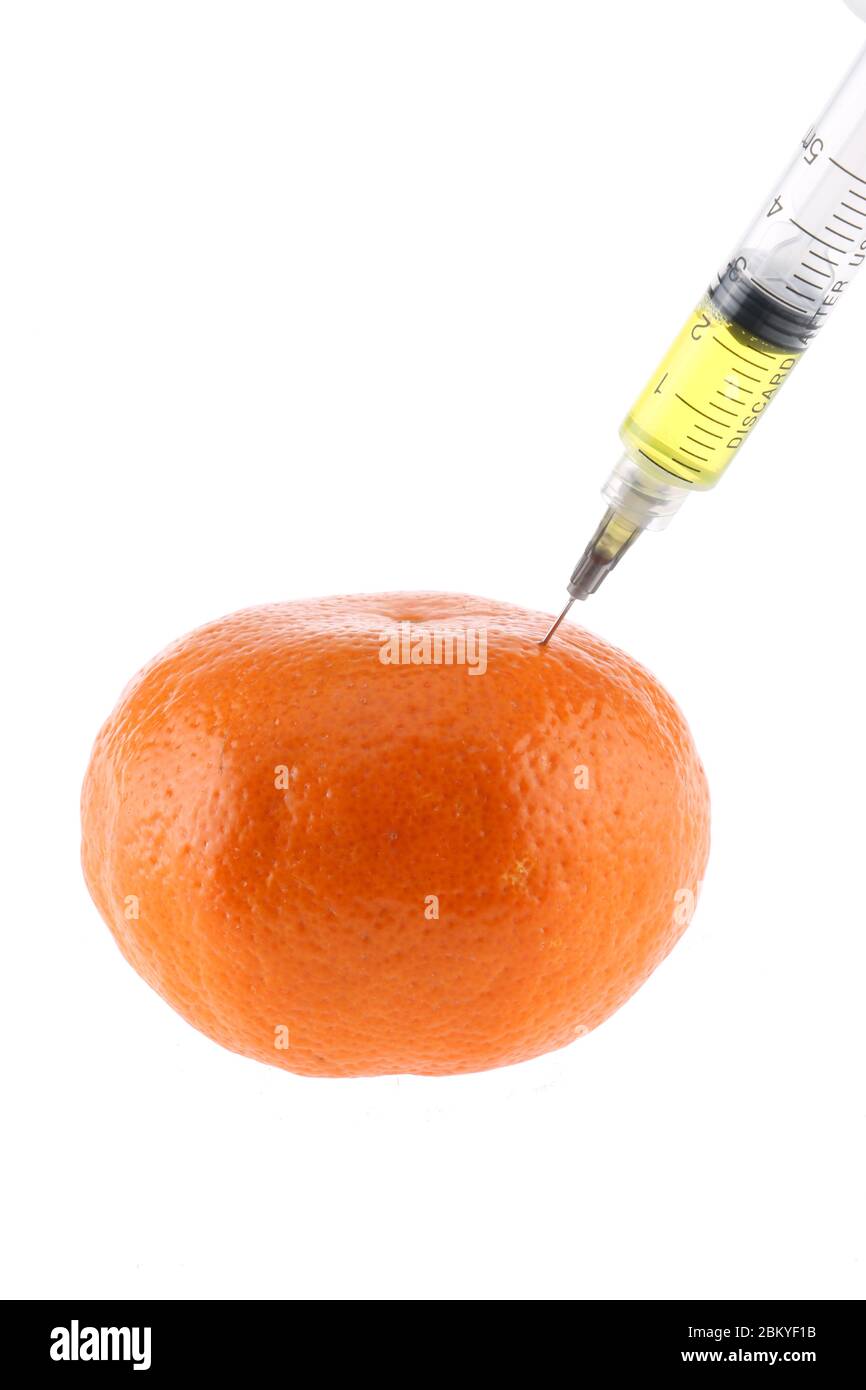 Arancione fresco con una siringa. Concetto per gli alimenti geneticamente modificati. Foto Stock