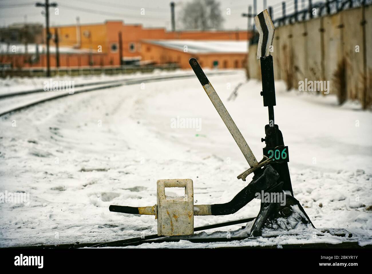 Freccia per cambiare la ferrovia. Vecchie rotaie ferroviarie. Sfondo zona industriale Foto Stock