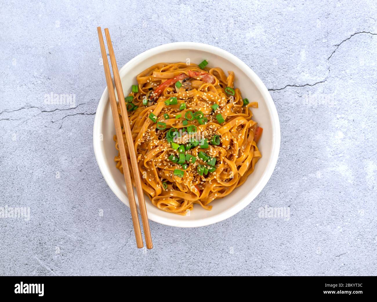 Composizione centrale di tagliatelle asiatiche con bacchette. Foto Stock