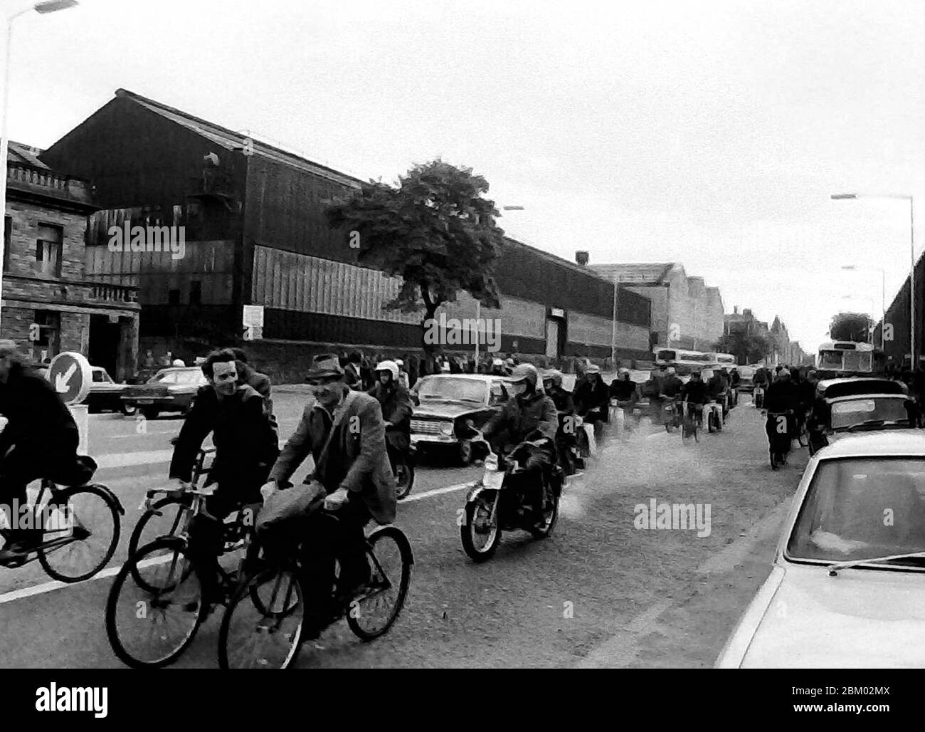 Gli uomini si allontanano dal lavoro in bicicletta nel Nord Ovest dell'Inghilterra, Regno Unito nel 1974 Foto Stock