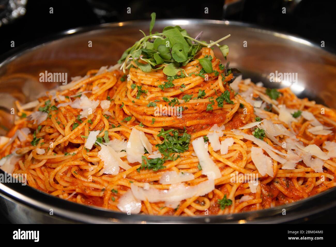 Spaghetti con salsa di pomodoro con cipolle e sedano serviti in una grande porzione in un recipiente grande. Foto Stock