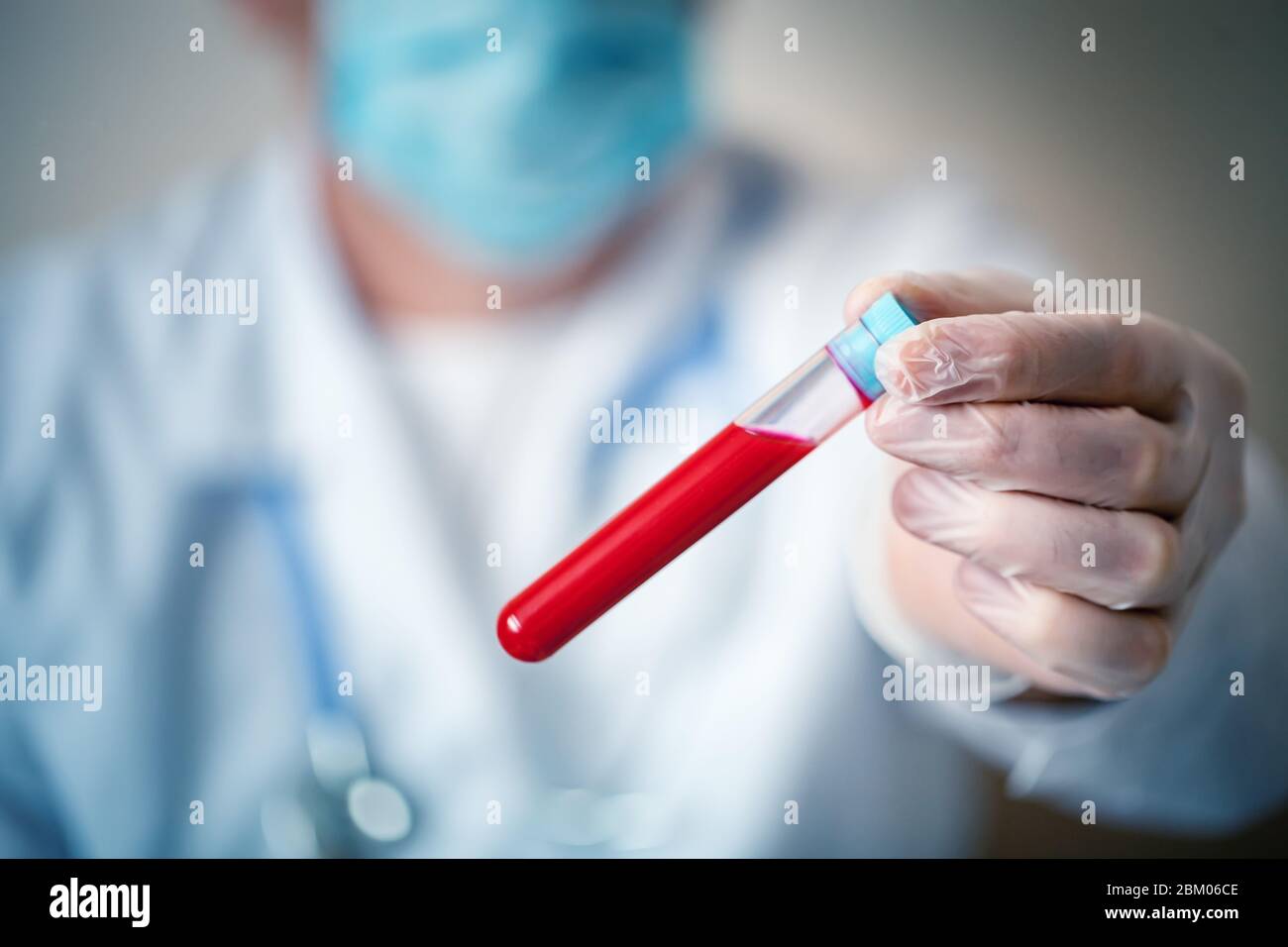 L'epidemia di coronavirus. Mano di un medico contenente un flacone di campione di sangue. Foto Stock