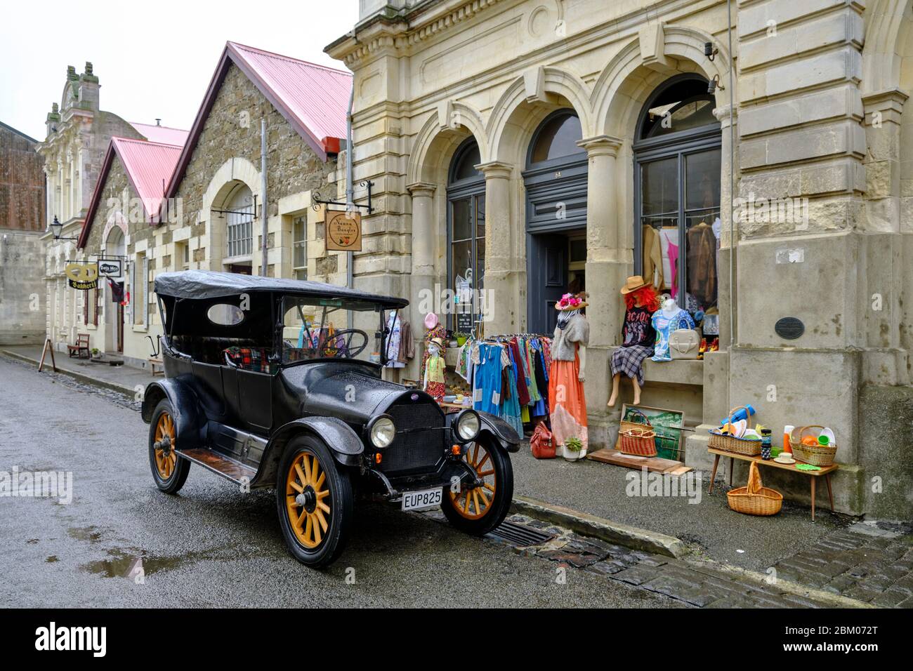 Auto d'epoca parcheggiata accanto ad un edificio classico in Oamaru Harbor Street, considerata la capitale mondiale della piroscafia. Foto Stock