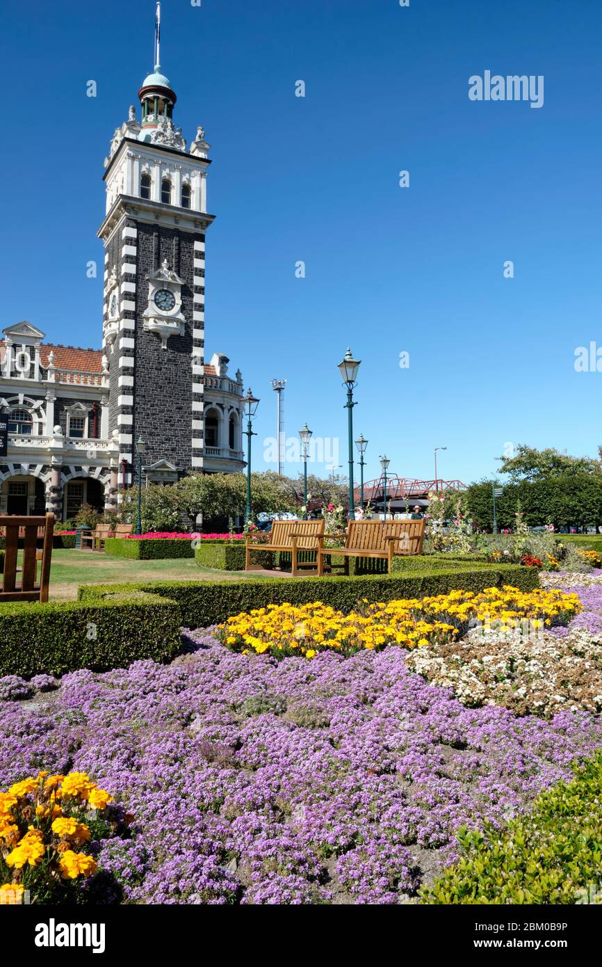 Giardini di fronte alla stazione ferroviaria di Dunedin, costruita in un eclettico stile rinascimentale fiammingo. Foto Stock