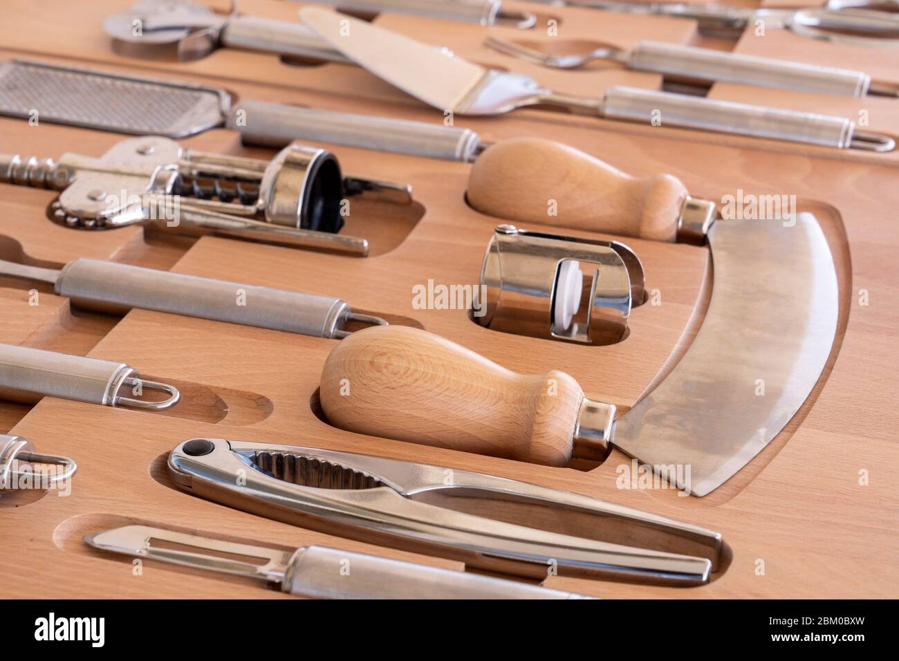 Utensili da cucina professionali per una cucina moderna in una scatola elegante di legno marrone Foto Stock