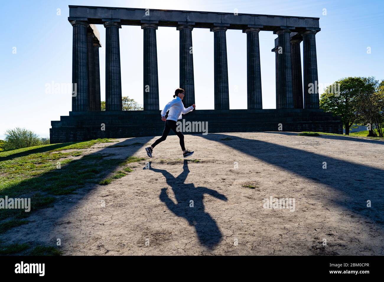 Edimburgo, Scozia, Regno Unito. 6 maggio 2020. Il sole ininterrotto e il tempo senza vento hanno dimostrato le condizioni belle per una ragazza jogger che si esercita quotidianamente durante il covid-19 a Calton Hill a Edimburgo oggi. La famosa destinazione turistica era praticamente deserta, con solo joggers locali e camminatori per cani fuori godendo il sole. Iain Masterton/Alamy Live News Foto Stock
