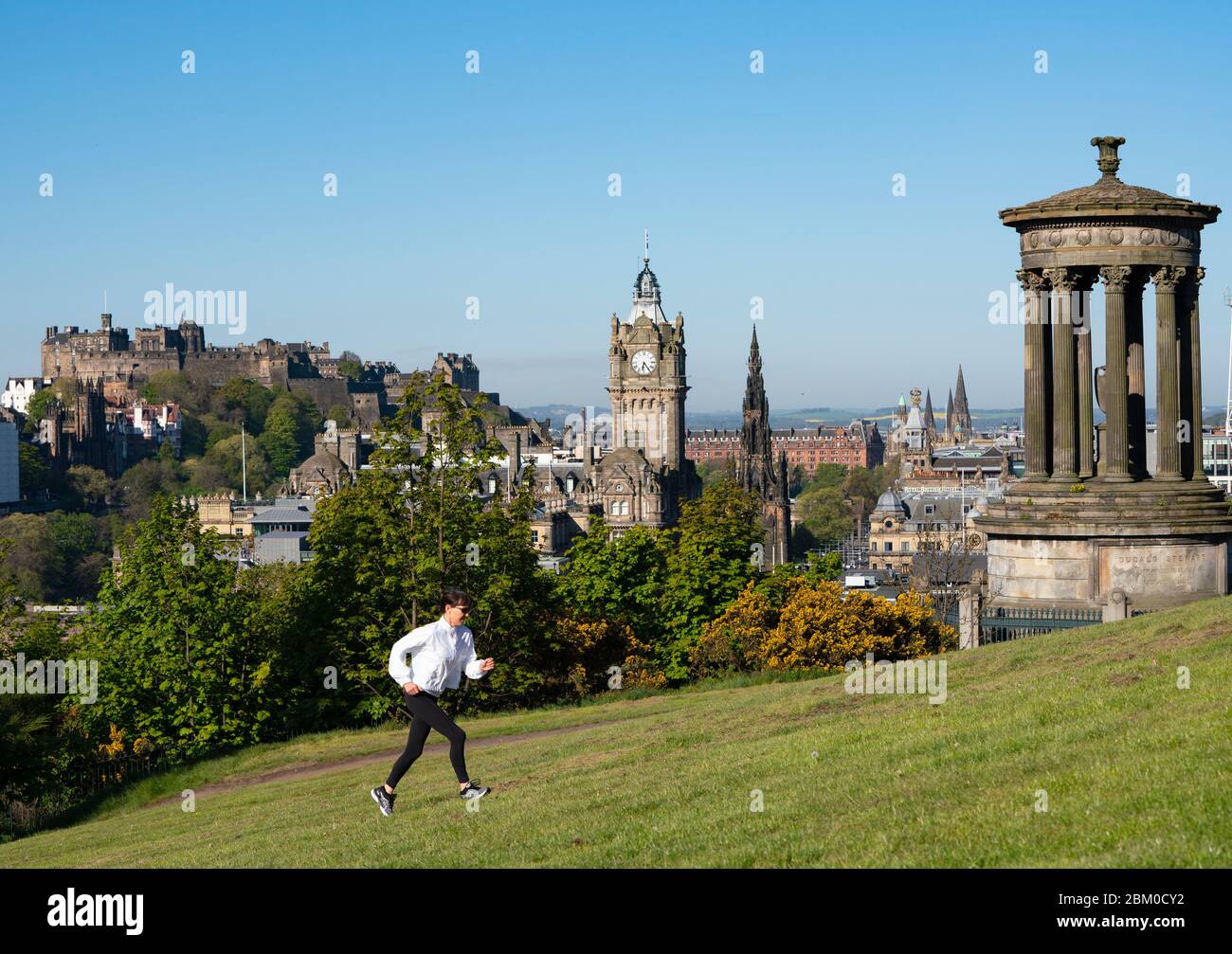 Edimburgo, Scozia, Regno Unito. 6 maggio 2020. Il sole ininterrotto e il tempo senza vento hanno dimostrato le condizioni belle per una ragazza jogger che si esercita quotidianamente durante il covid-19 a Calton Hill a Edimburgo oggi. La famosa destinazione turistica era praticamente deserta, con solo joggers locali e camminatori per cani fuori godendo il sole. Iain Masterton/Alamy Live News Foto Stock