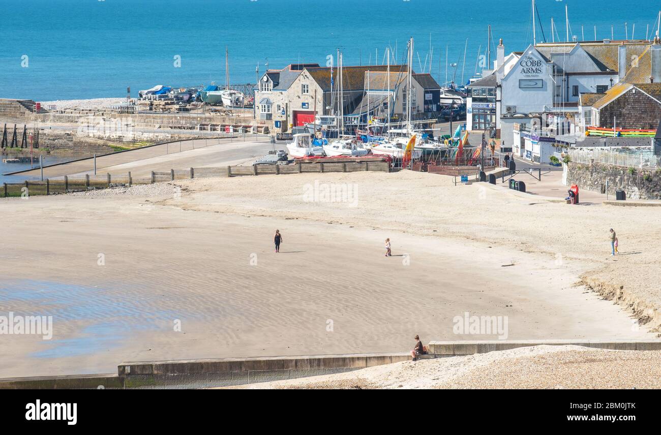 Lyme Regis, Dorset, Regno Unito. 6 maggio 2020. UK Weather: Sole caldo e cielo azzurro limpido nella località balneare di Lyme Regis in vista del weekend di vacanza della VE Day Bank. La bella spiaggia rimane vuota a parte alcune persone che si prendono loro permesso esercizio quotidiano, come il pubblico in gran parte continuano a rispettare le istruzioni del governo di rimanere a casa. Le restrizioni COVID-19 sono in vigore da 44 giorni e sono devastanti il turismo e le imprese locali in tutto il Sud-Ovest. Credit: Celia McMahon/Alamy Live News Foto Stock