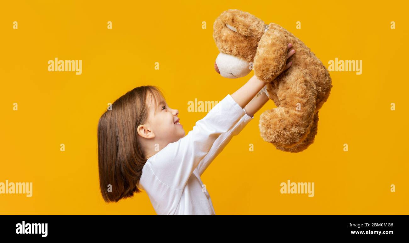 Ragazza allegra che tiene grande orso peloso giocattolo Foto Stock