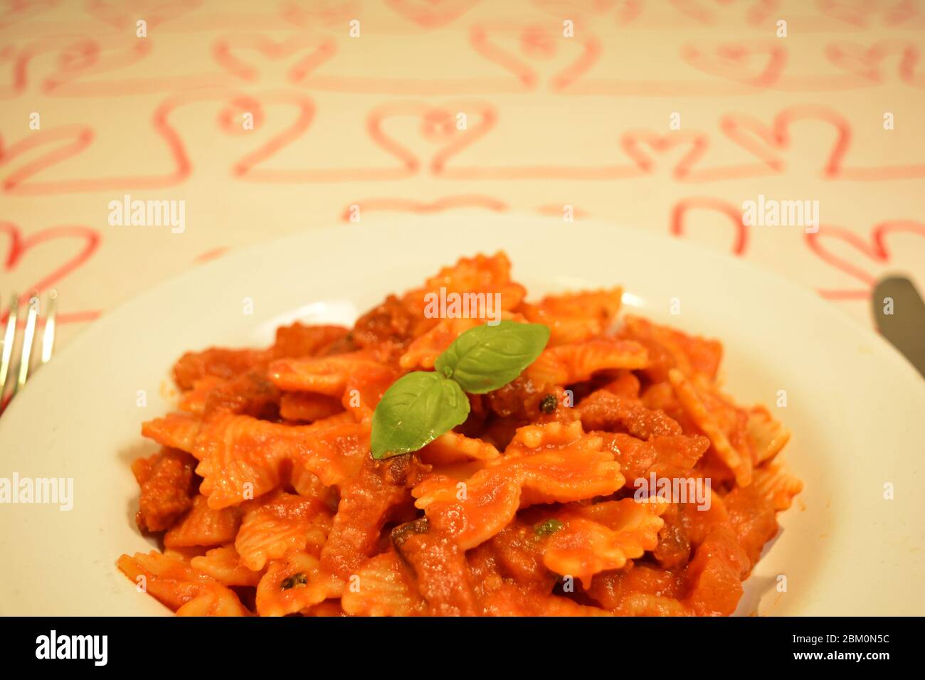 Delizioso primo piano di un gustoso piatto di pasta all'Amatriciana. Specialità gastronomiche italiane a base di tagliatelle, pancetta, guancia di maiale, salsa di pomodoro Foto Stock