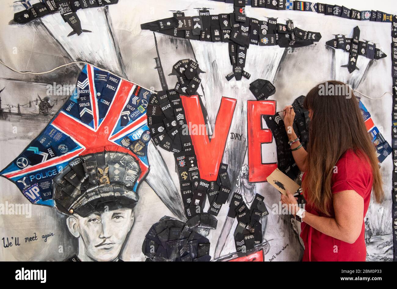 L'artista Sam Bailey aggiunge un tocco finale a un murale con il capitano Tom Moore (a sinistra) e il sergente della guardia Grenadier Eric Presland, per celebrare il 75° anniversario del VE Day, a casa sua a Northampton. Foto Stock