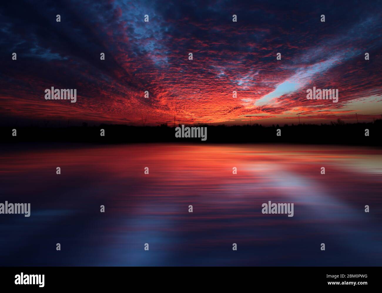 Il tramonto rosso e blu con riflessi Foto Stock