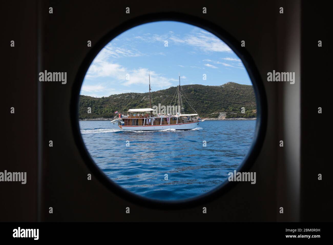 Una nave turistica in legno a vela fotografata attraverso una silhouette di una finestra di navi Foto Stock