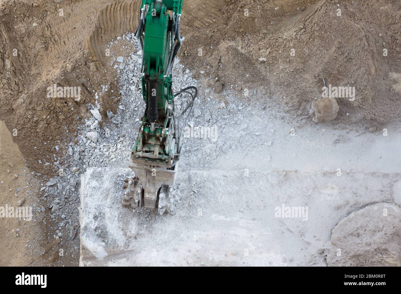 rimozione di fondamenta in calcestruzzo con unità di taglio su un digger Foto Stock