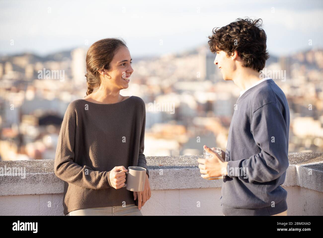 Fratello e sorella che parlano mentre bevono Foto Stock