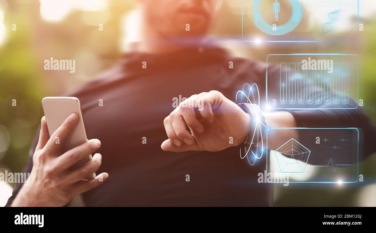 Ragazzo caucasico muscolare guardando il suo orologio intelligente Foto Stock
