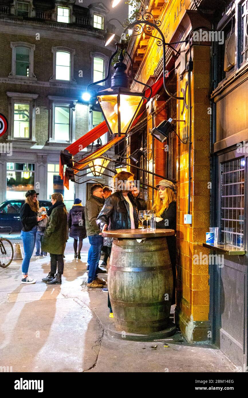 Persone che stanno in piedi e chiacchierano fuori dal pub Southwark Tavern a London Bridge, Londra, Regno Unito Foto Stock