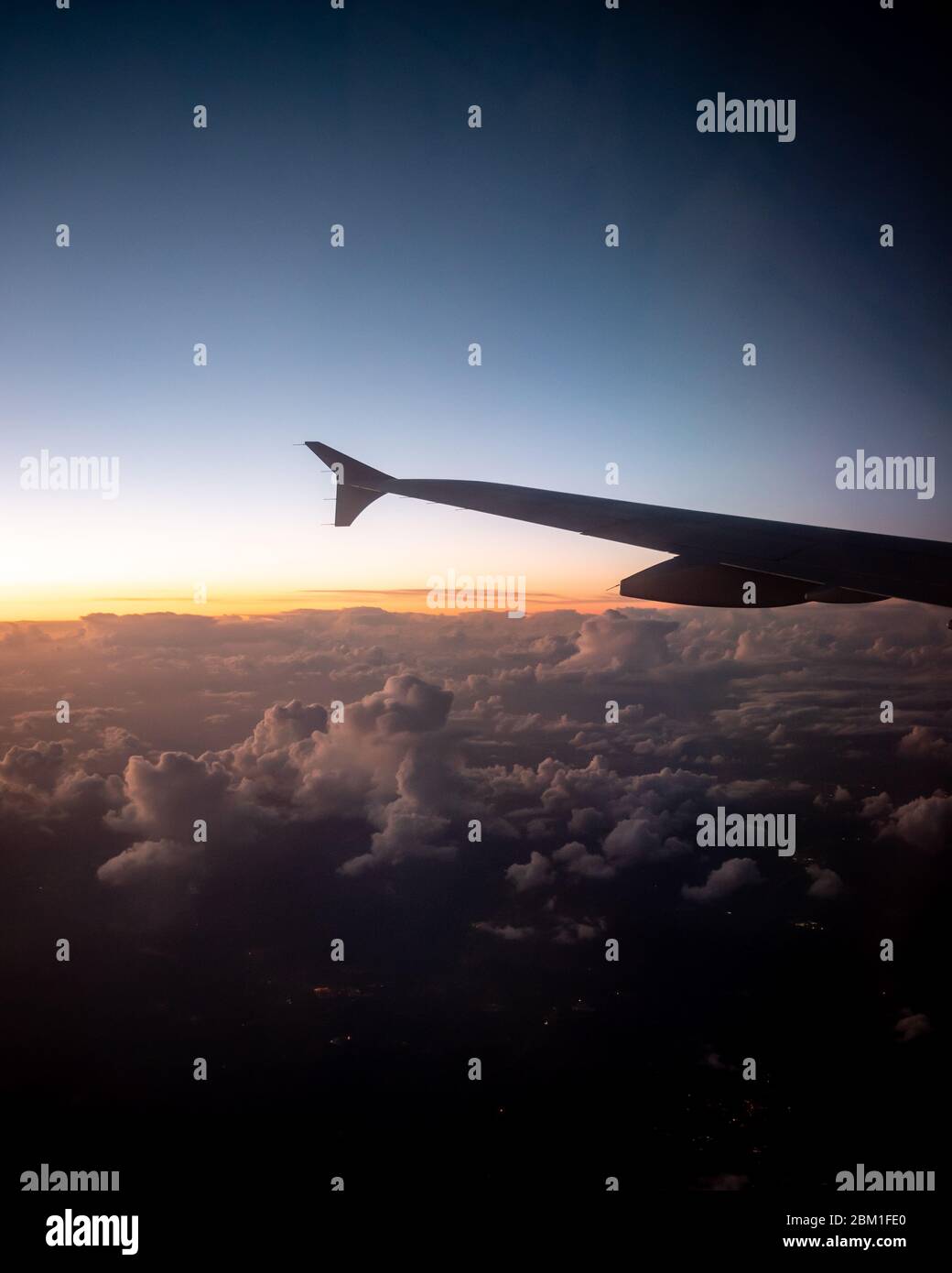 Volo serale. Una vista sopra le nuvole da un aereo come crepuscolo cade. Foto Stock