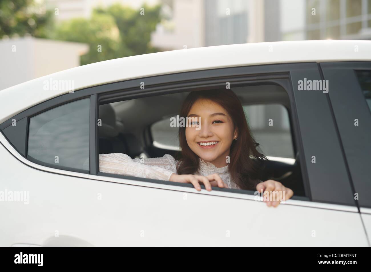 Ritratto di felice giovane donna farà un viaggio proteso al di fuori della finestra. Femmina di godersi il viaggio in automobile con il suo fidanzato. Foto Stock